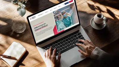 The website of the Diakonie clinic in a notebook mockup scene.