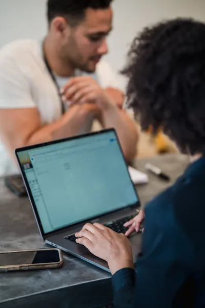 Two people working together on a laptop